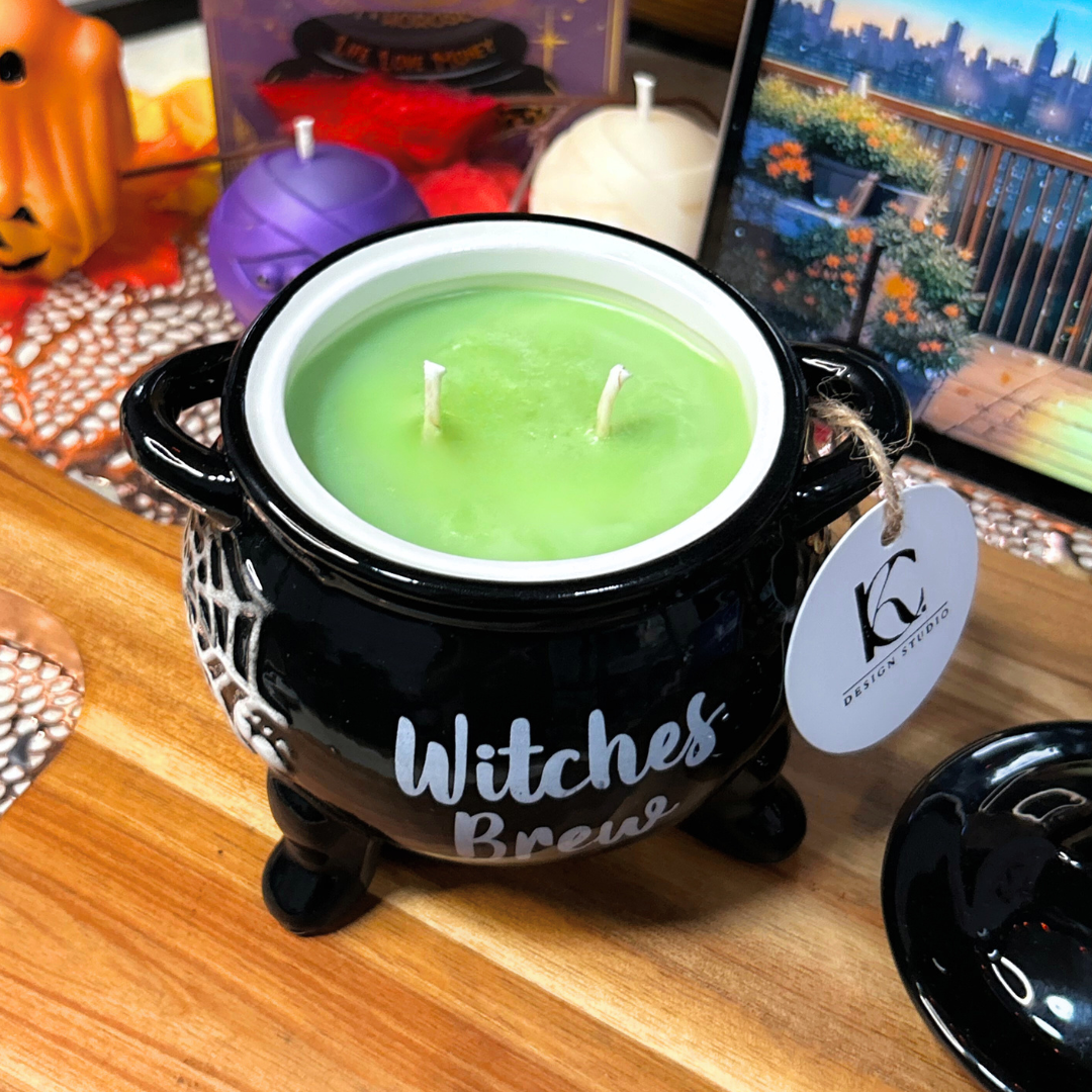 Black cauldron-shaped candle with a green layer labeled "Witches Brew" on a wooden surface.