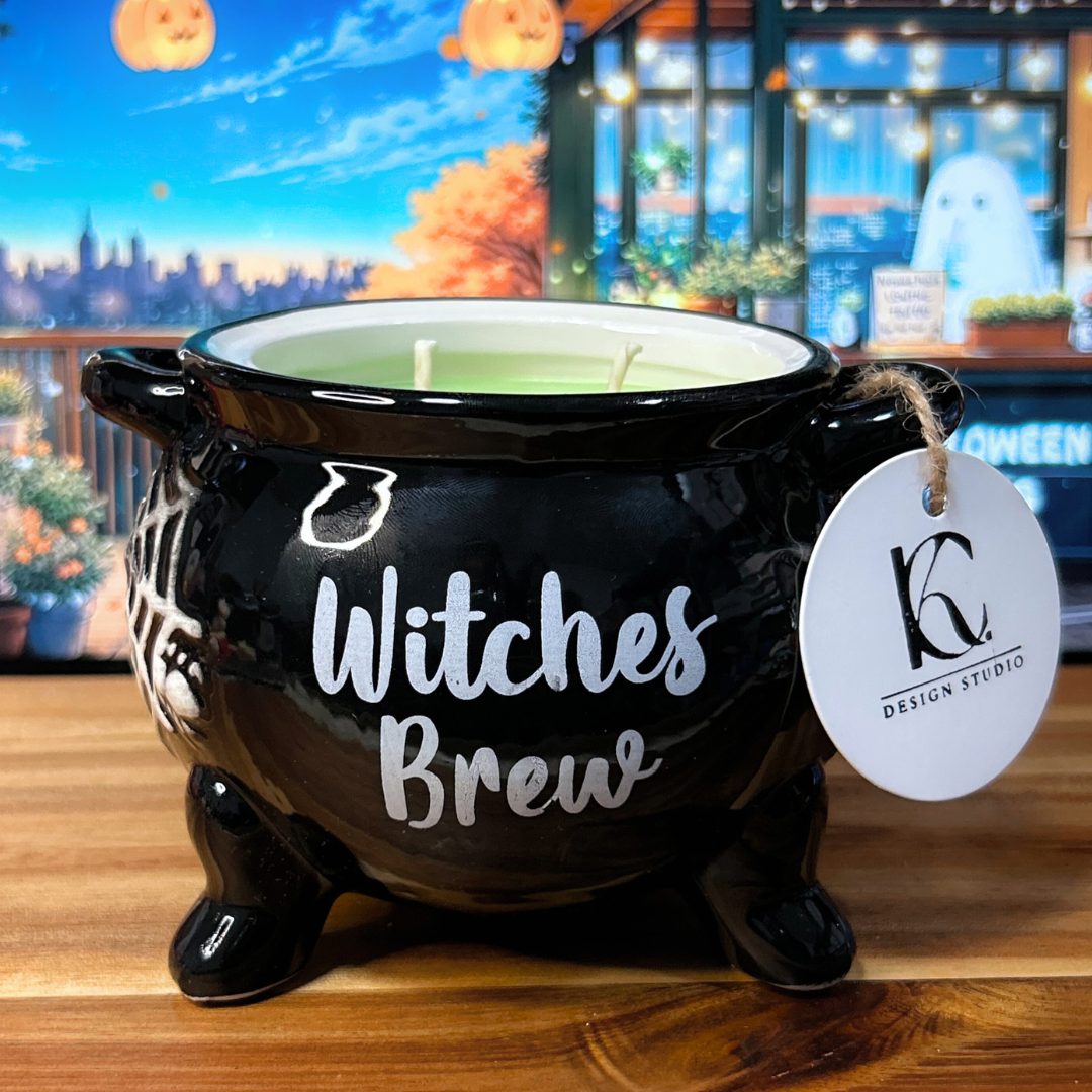 Black cauldron-shaped candle with "Witches Brew" text and a tag on a wooden surface.