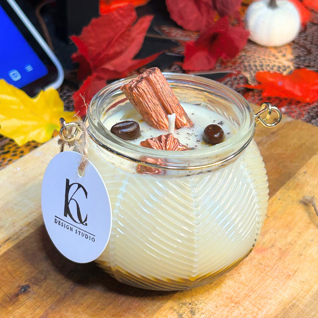 Angled view of Autumn Roast Candle – layered cappuccino espresso and marshmallow soy wax candle with cinnamon stick, brown flower, two coffee beans, and brown mica powder, cozy fall vibes.