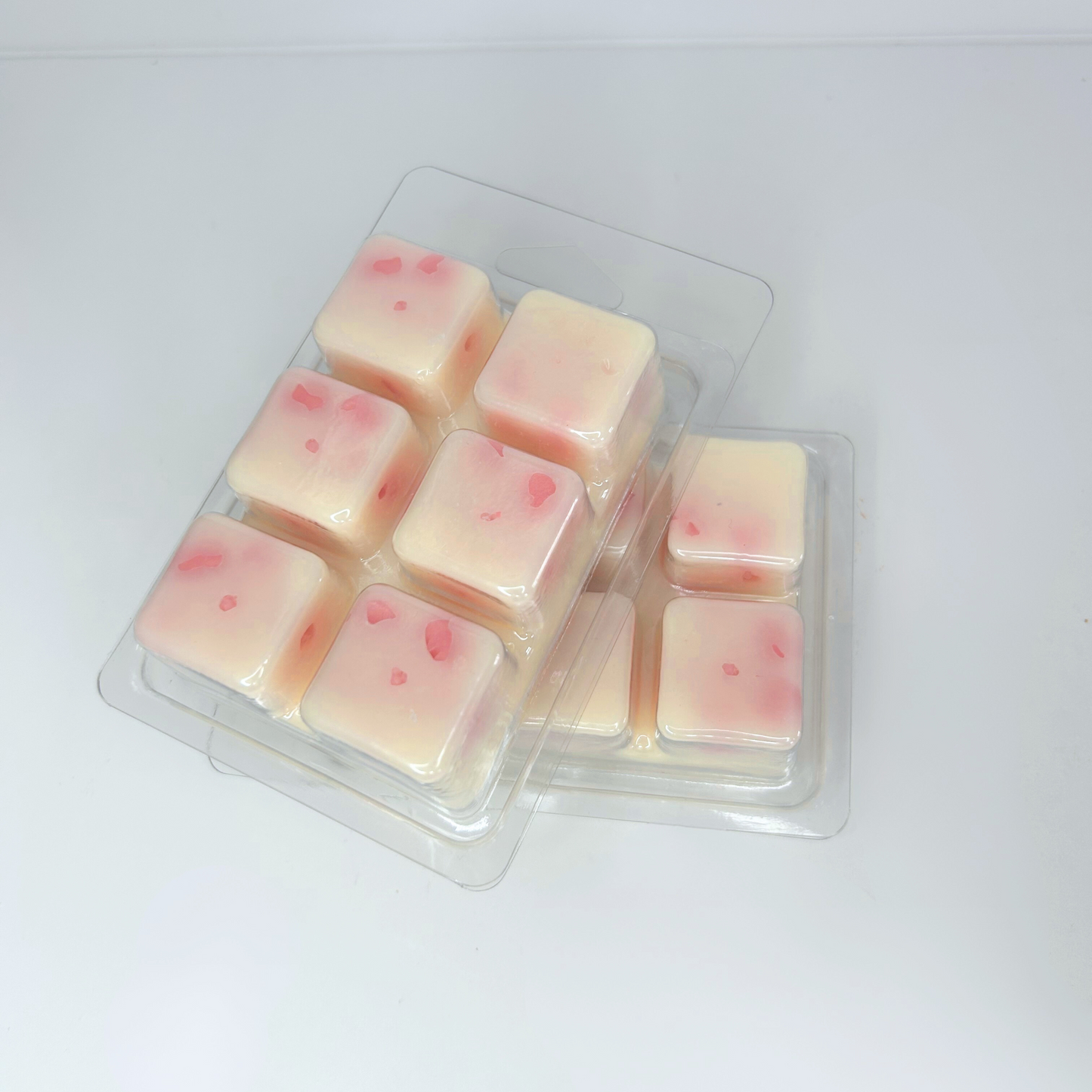 Back side of the Blossom Sea wax melt, revealing pink cherry blossom wax flowers peeking through the peach magnolia wax.