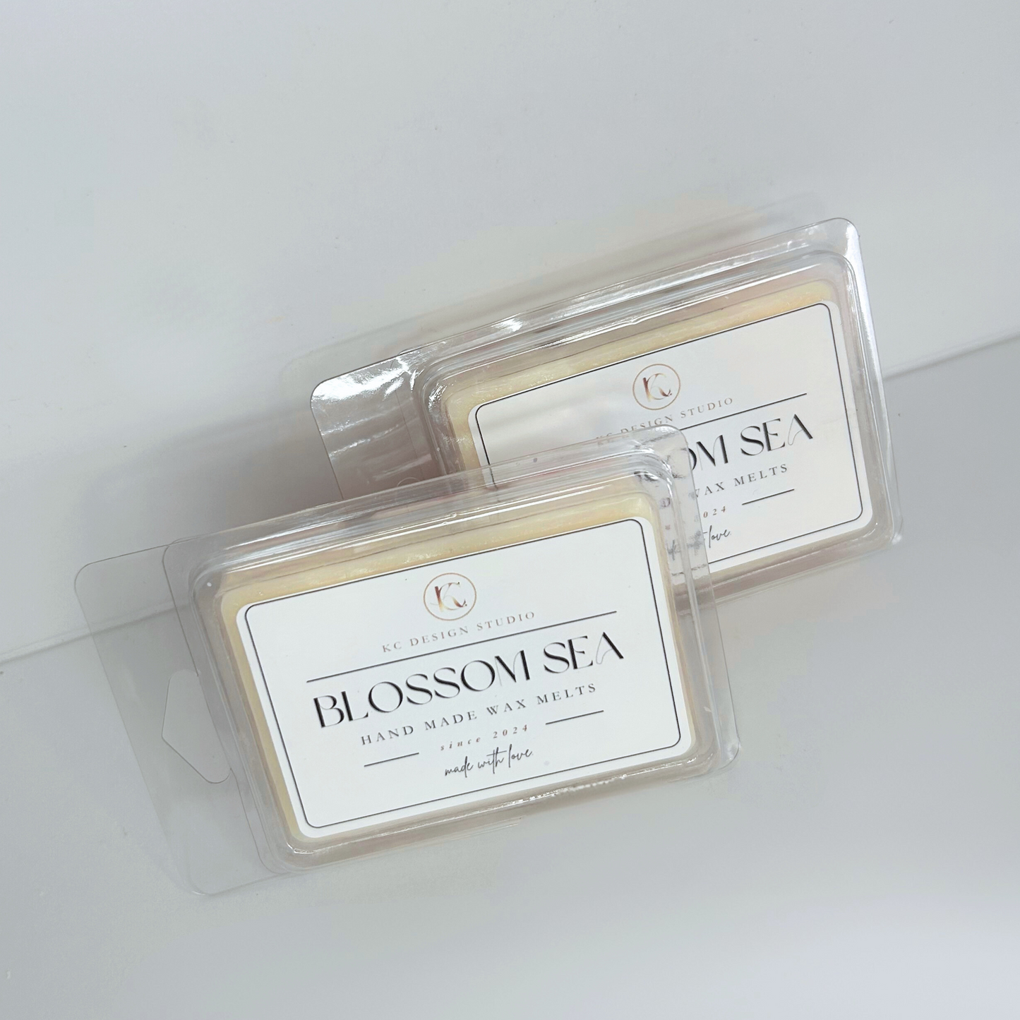 Blossom Sea wax melt – top view of a square-shaped soy wax melt with peach magnolia wax and pink cherry blossom flower details.