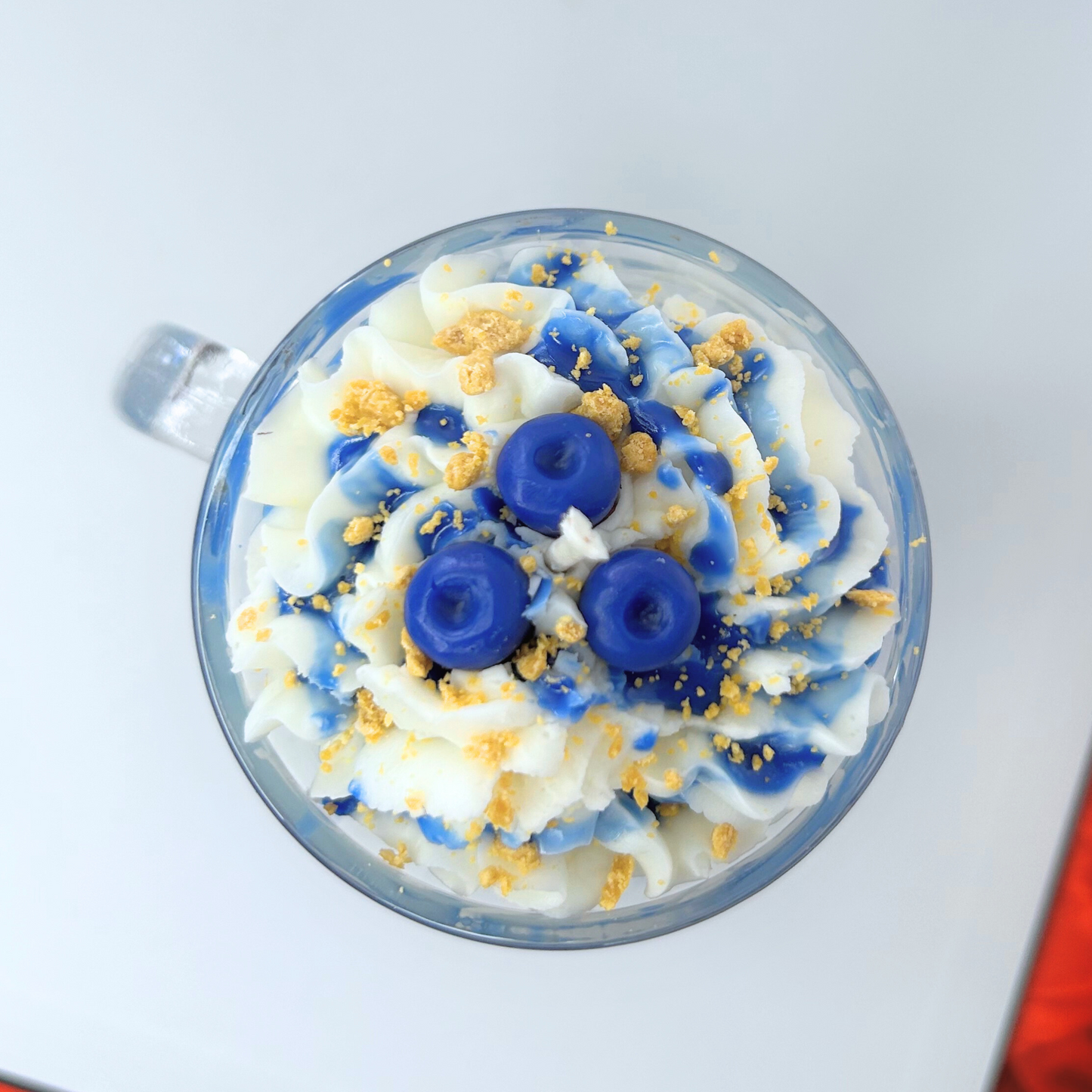 Top view of Blueberry Milkshake Candle showcasing whipped cream, caramel crumbs, syrup drizzle, and three blueberries.