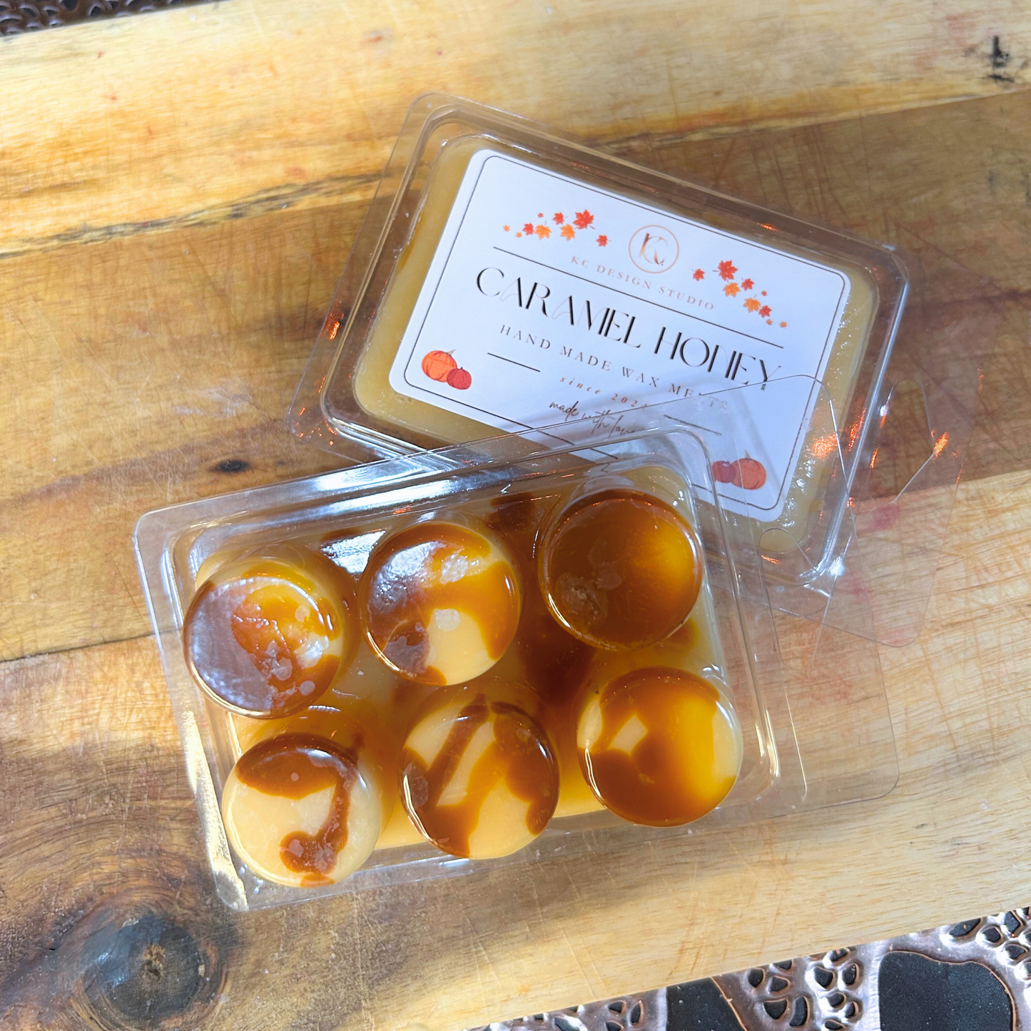 Packaged caramel honey on a wooden surface, top view of round Caramel Honey Wax Melts with swirl design, perfect autumn home fragrance.
