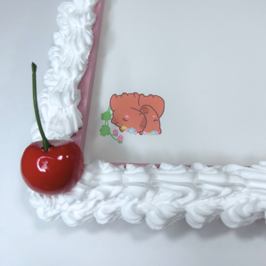 Close-up of white frosted pink whiteboard corner with cherry decoration.