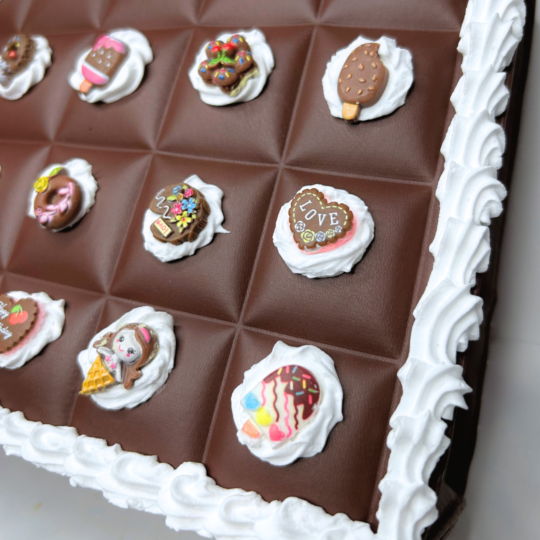 Close-up of mini brown kawaii charms on the Chocolate Bar Purse with frosting accents.