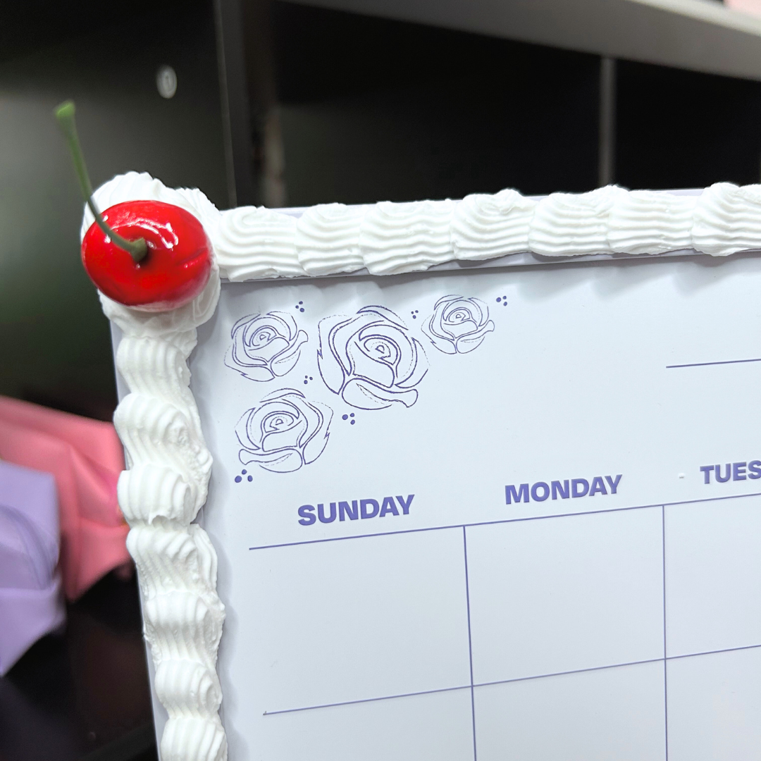Calendar with a cherry on top of white frosting frame.