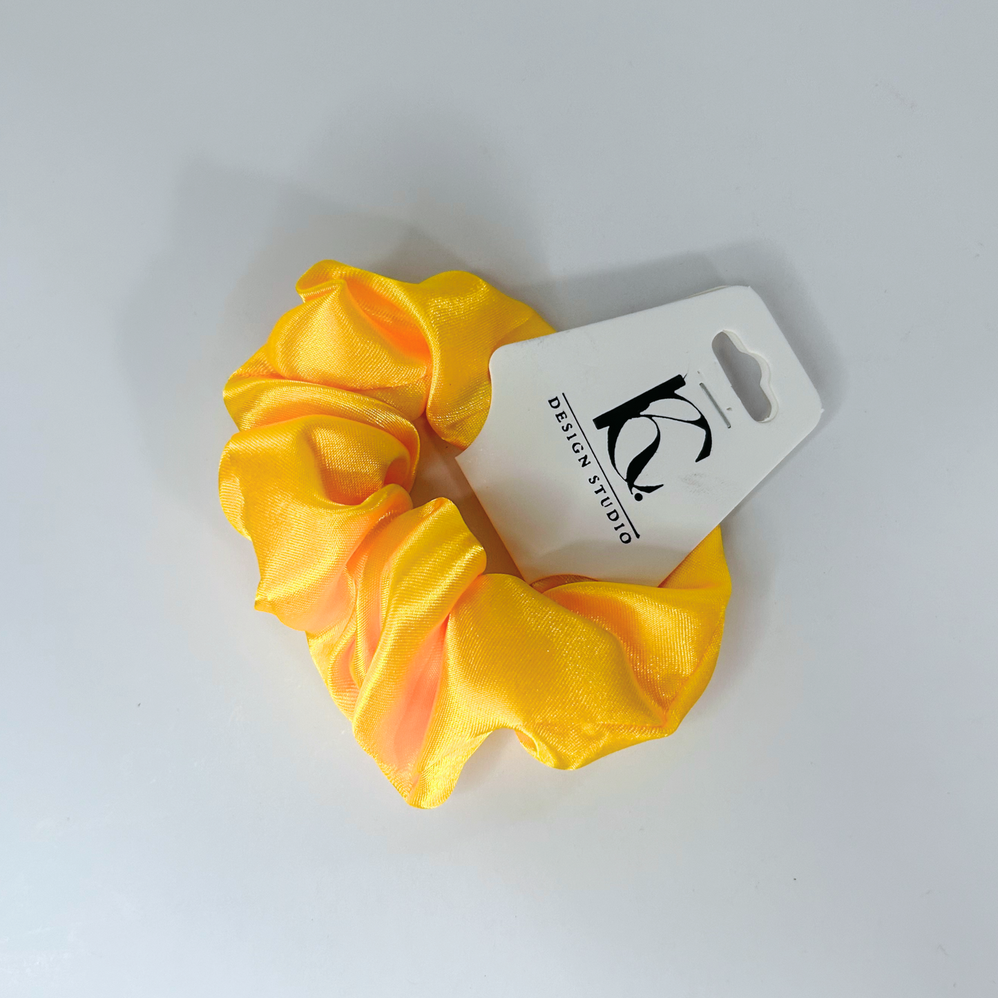 Glamorous gold silk scrunchie adding a touch of luxury to any hairstyle.