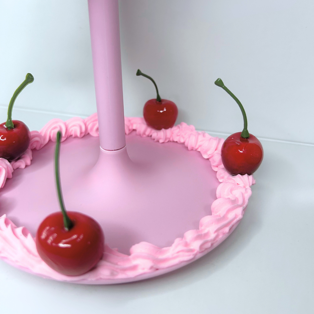 Close-up of cherry storage tray and base of heart-shaped cake-inspired LED mirror.