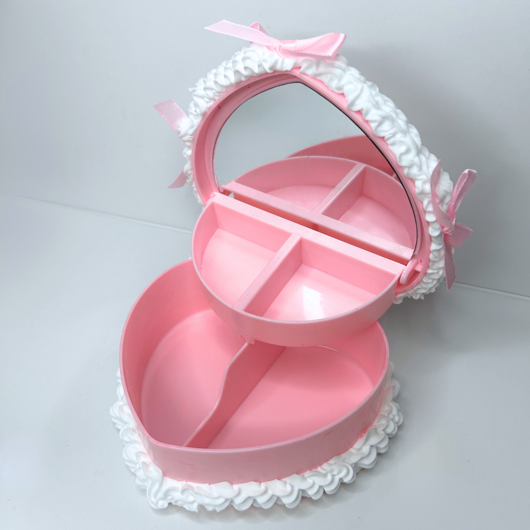 Top view of the heart-shaped cake jewelry box opened, showing the interior storage for rings and accessories.