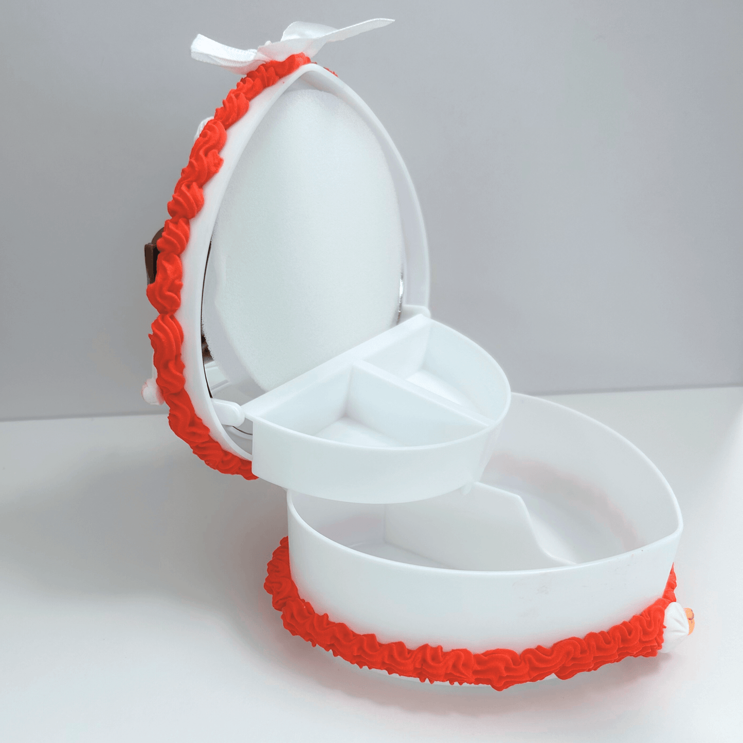 Open view of the heart-shaped jewelry box revealing its interior, with cute foodie charms surrounding the edge and a cherry topping.