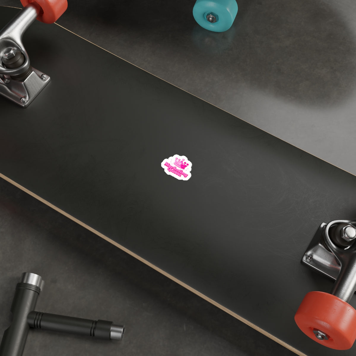 Marketing Queen sticker stuck on a skateboard, showcasing water-resistant vinyl and vibrant colors.