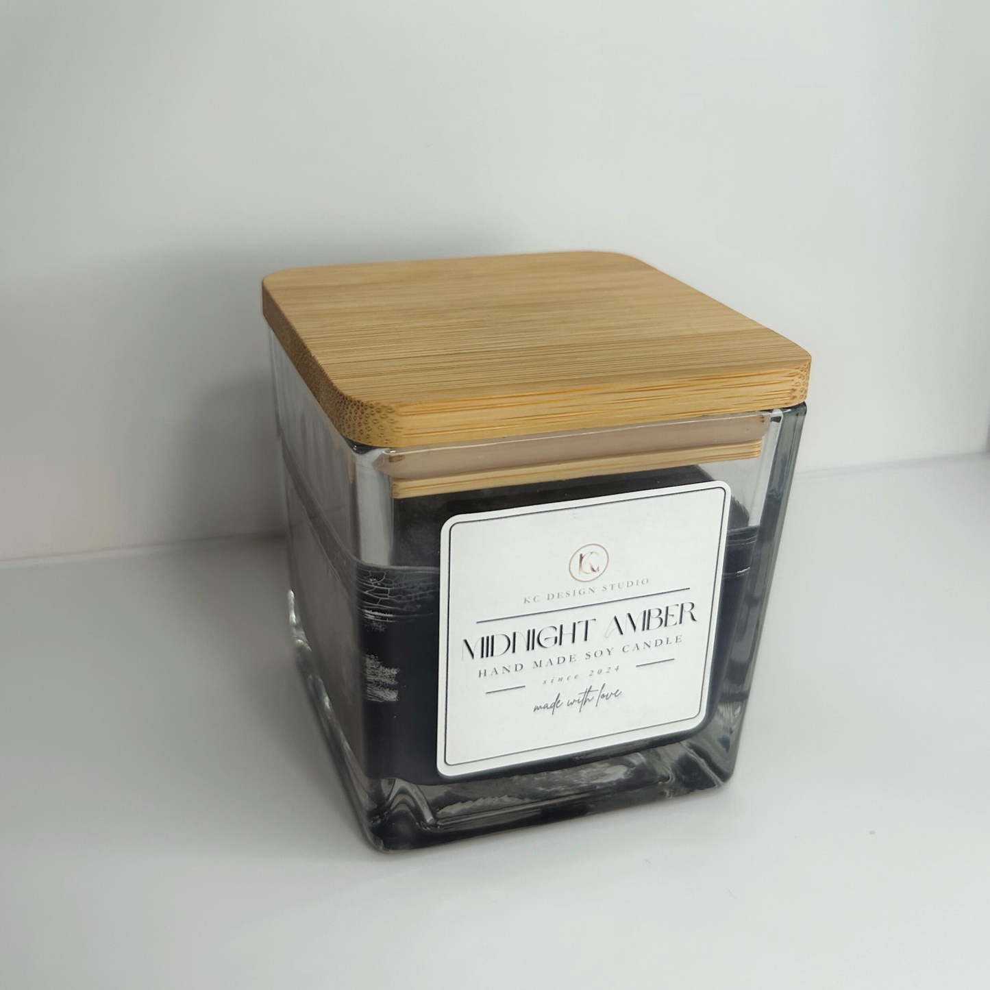 Top view of the 10oz Midnight Amber Candle with the lid on, revealing its elegant design and rich scent profile.