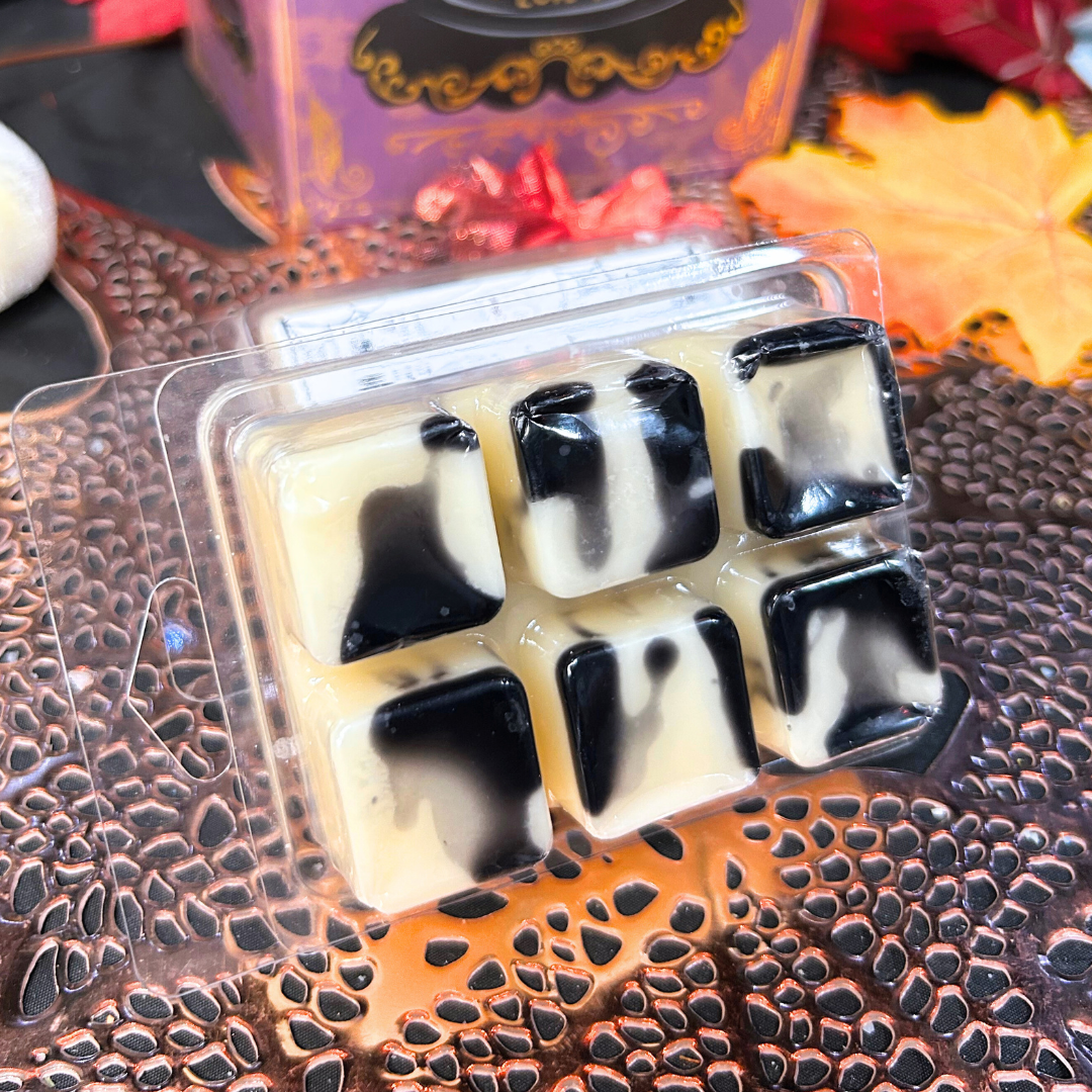 Back view of Other Mother wax melt with white base, black syrup swirl, and black button accents in square shape
