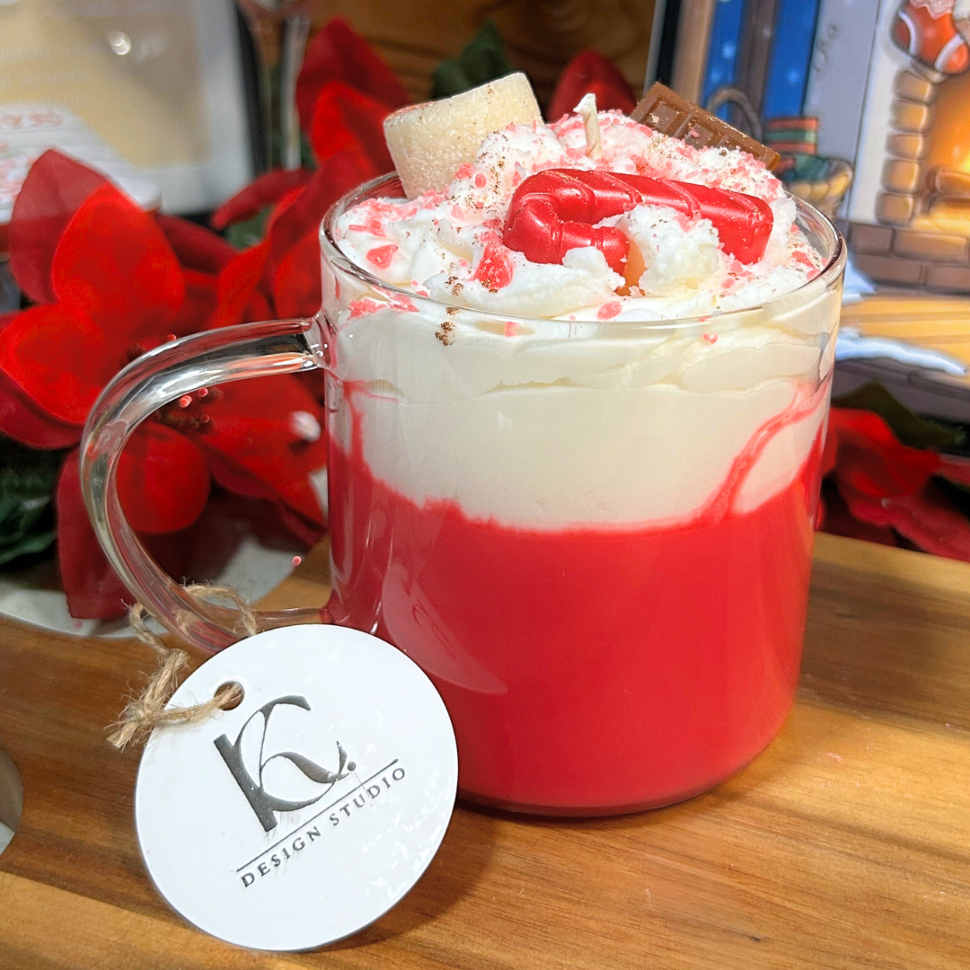 Front view of a peppermint cocoa mug candle with red base, marshmallow whip, chocolate pieces, and peppermint toppings.