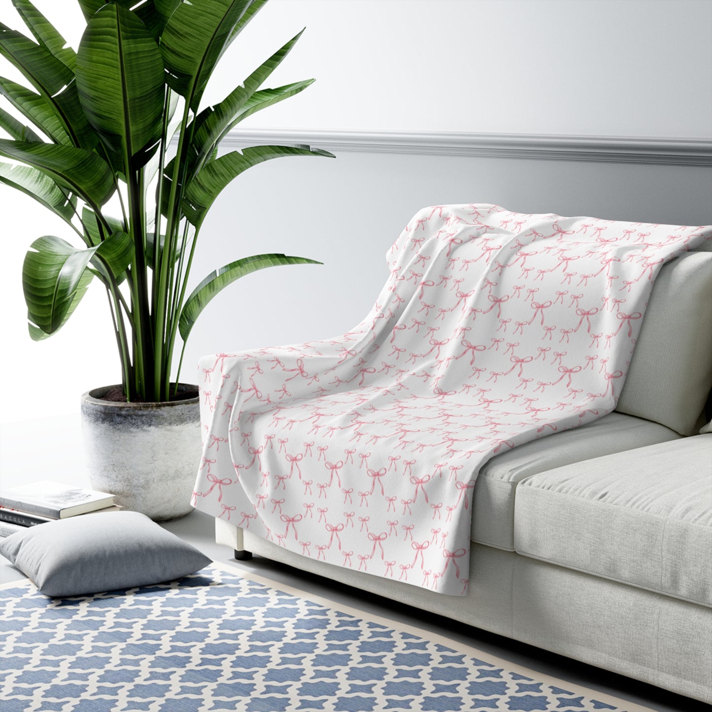 White sofa with a pink patterned throw blanket in a living room setting.