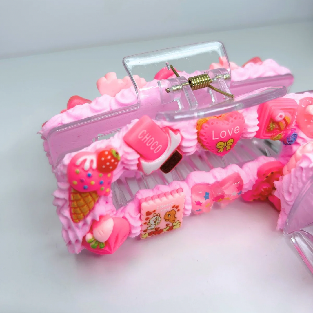 Close-up of pink creamy hair claw showcasing adorable charms and geometric design.