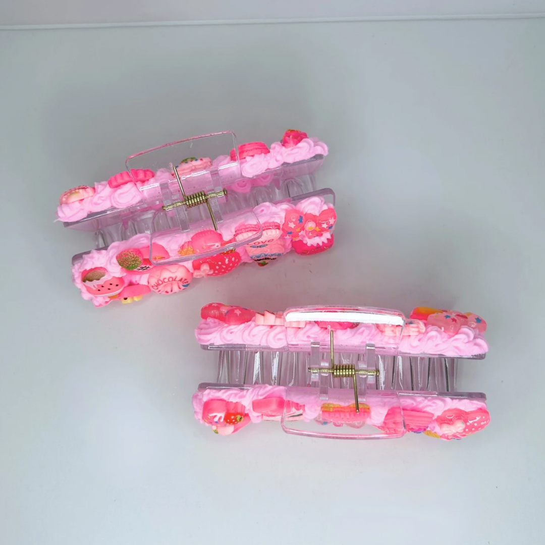 Pink creamy hair claws with geometric design and adorable charms - top view.