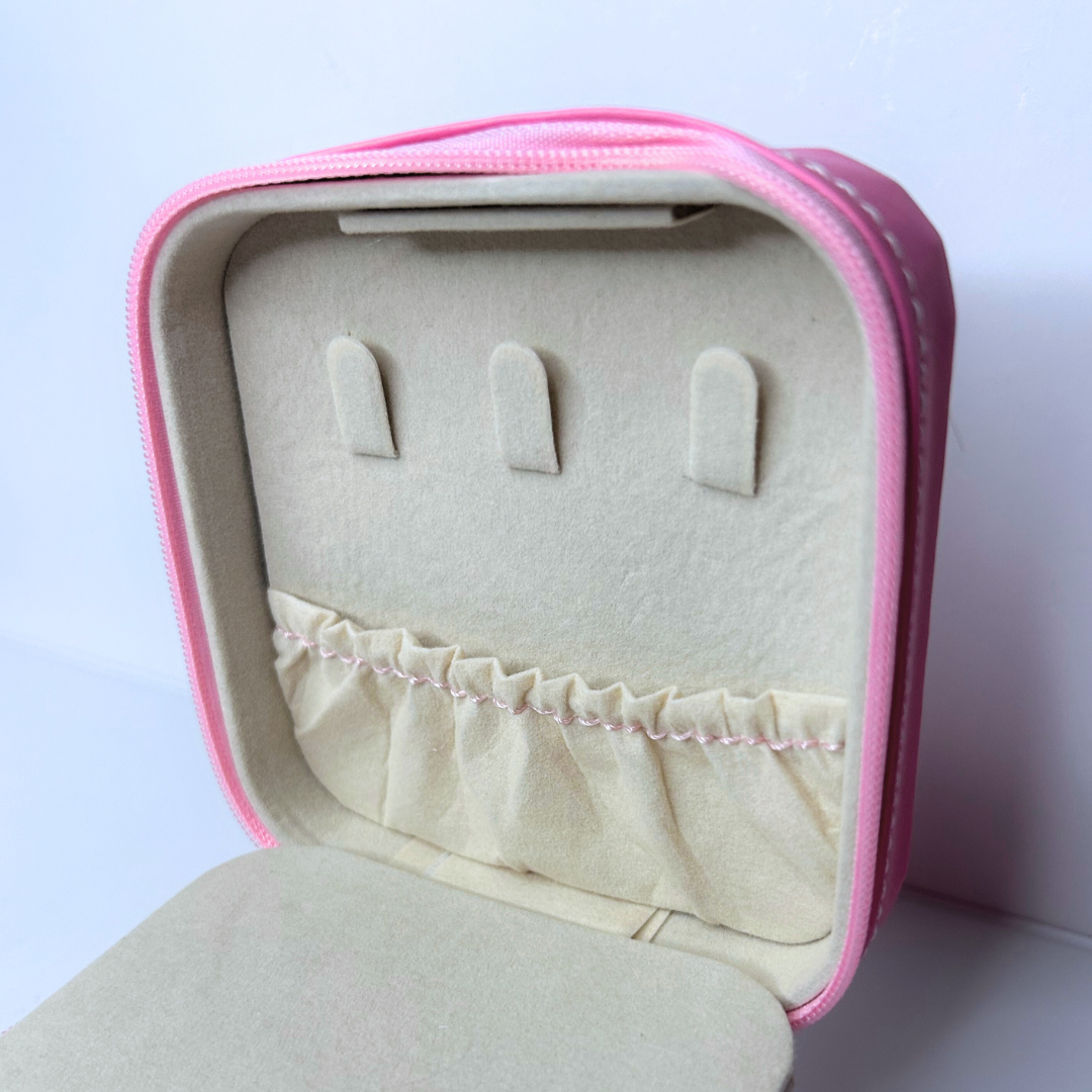 Detailed view of back compartment inside pink square jewelry case.