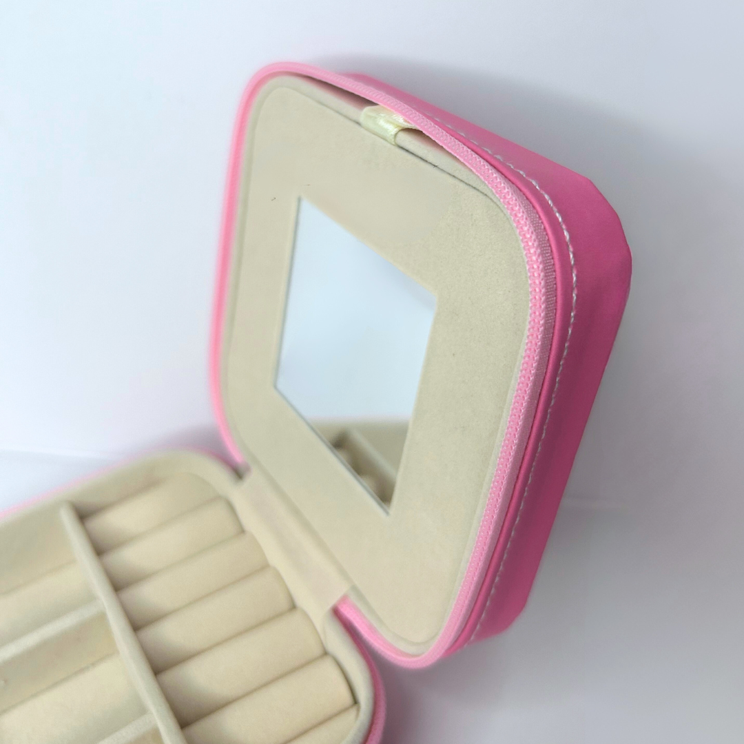 Close-up of mirror inside pink square jewelry travel case.