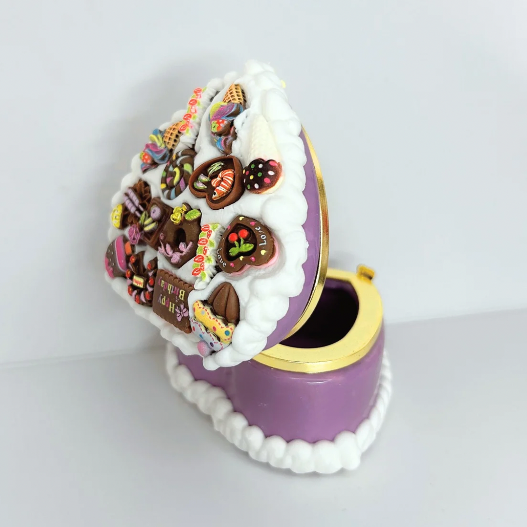 Back side open view of a purple kawaii heart-shaped jewelry box with curvy cream details, showcasing its design and functionality.