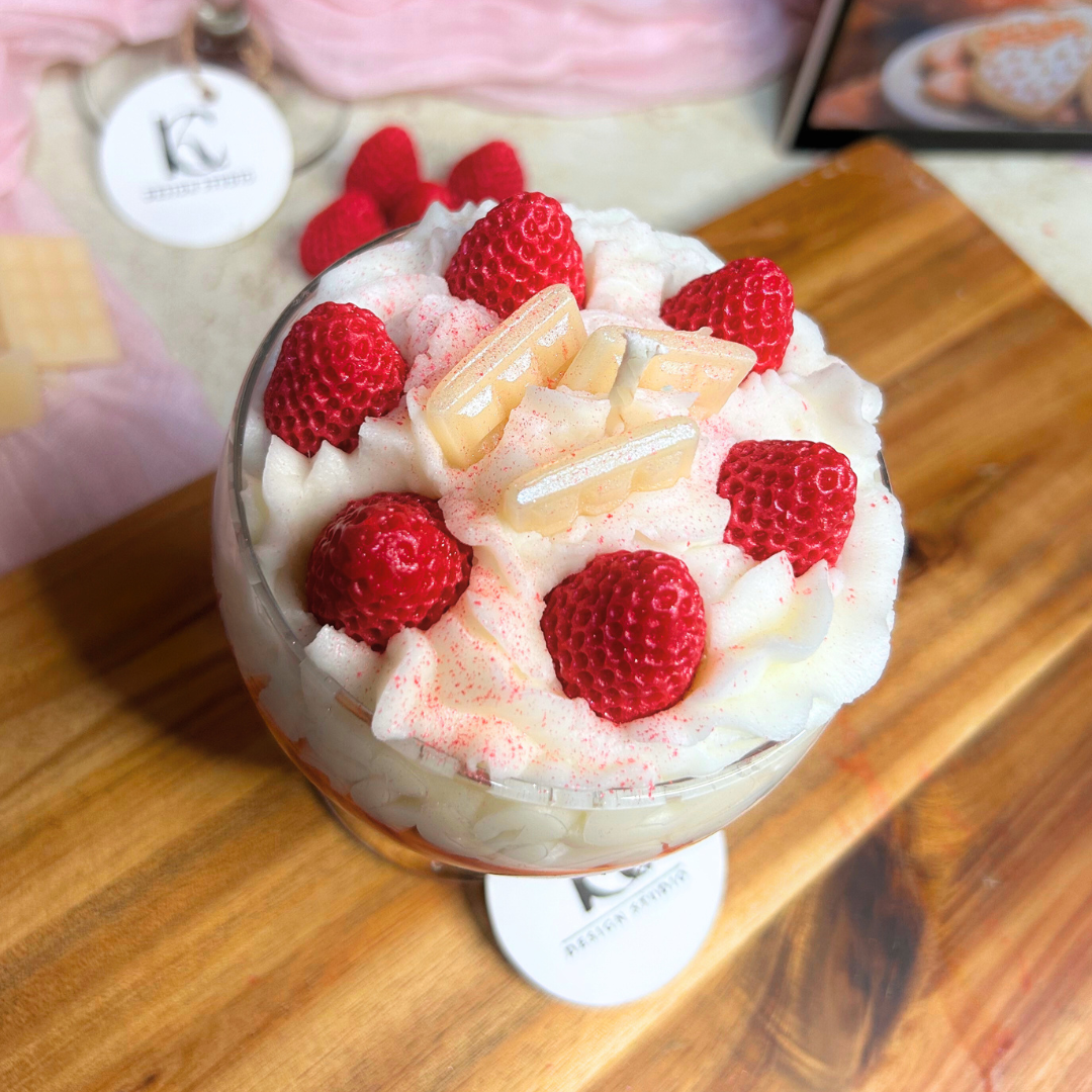 Top view of Red Velvet Berry candle showing whipped cream, five strawberries, and white chocolate bar details in a cozy Valentine’s setup