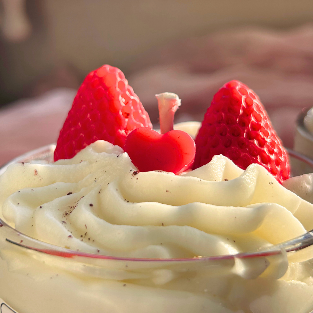 Close-up of a strawberry shortcake candle highlighting intricate frosting and strawberry details.