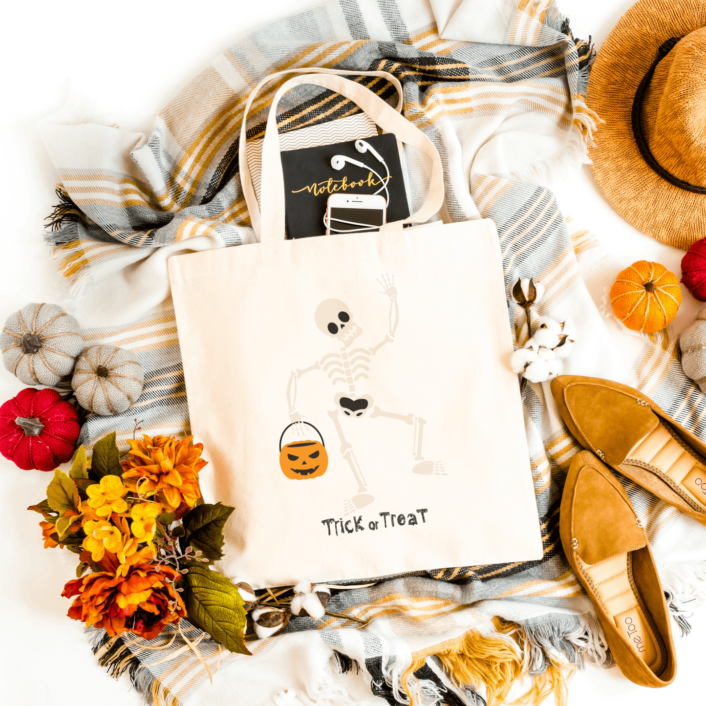 White Trick or Treat Halloween Tote featuring a playful skeleton holding a pumpkin basket, perfect for Halloween candy collection.