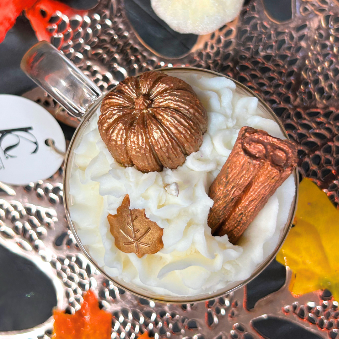 Top view of Vanilla Pumpkin Pie candle with whipped cream, pumpkins, and leaves on a decorative surface.