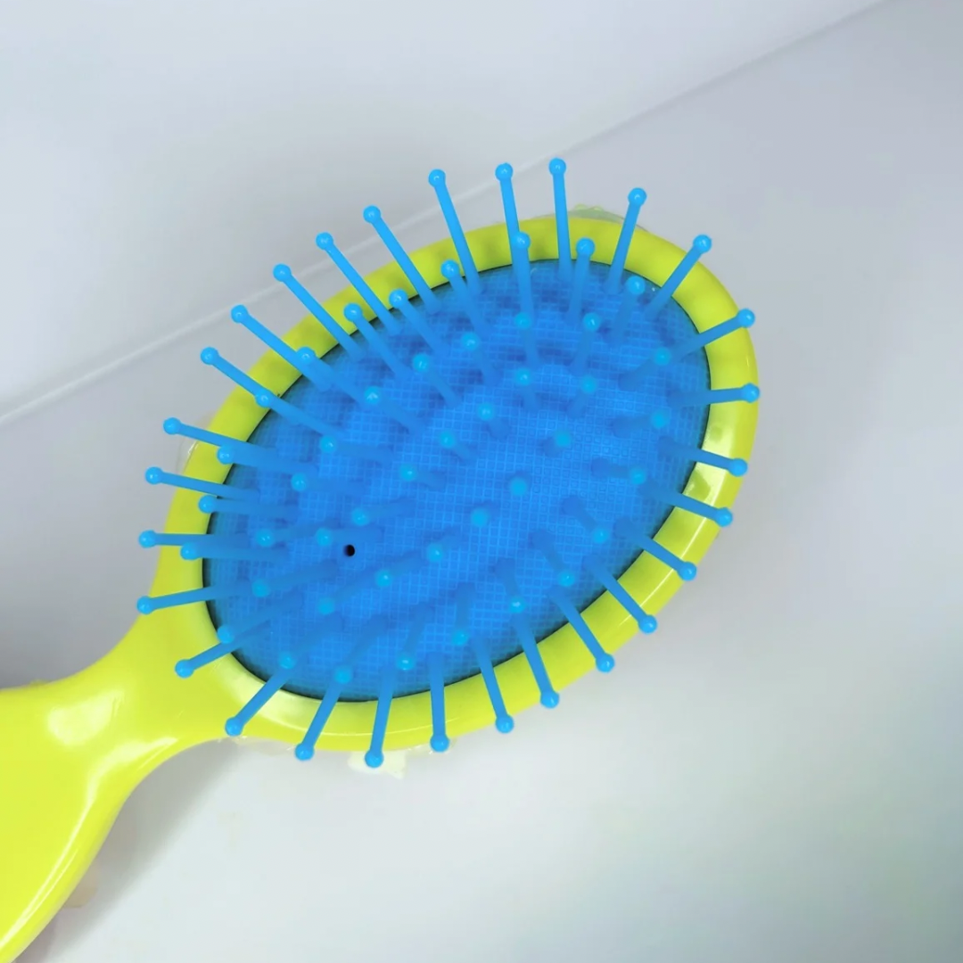 Close-up of the yellow brush’s flexible silicone bristles, made to glide through hair with no tugging