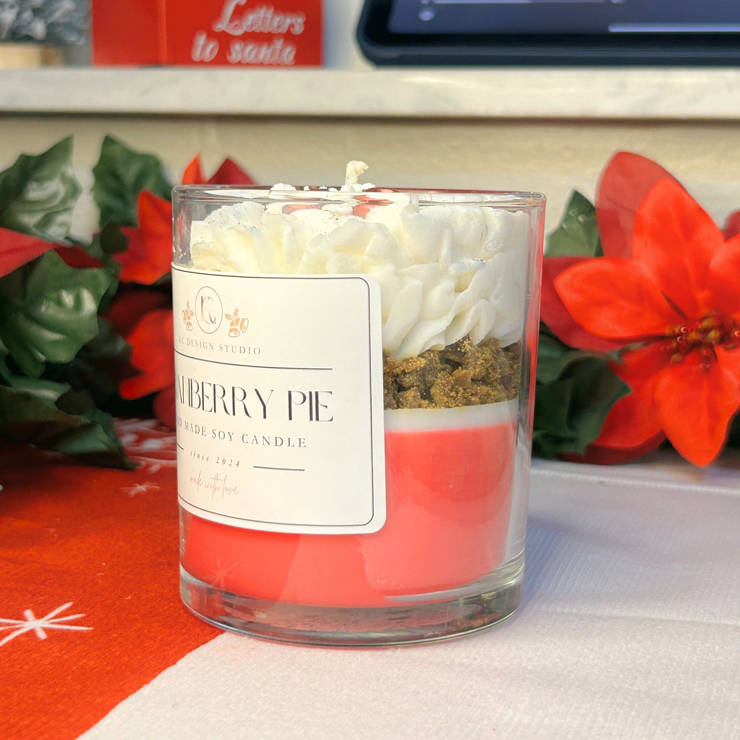 Side view of 4oz cranberry pie candle with vibrant red, white layers and brown crumbs.