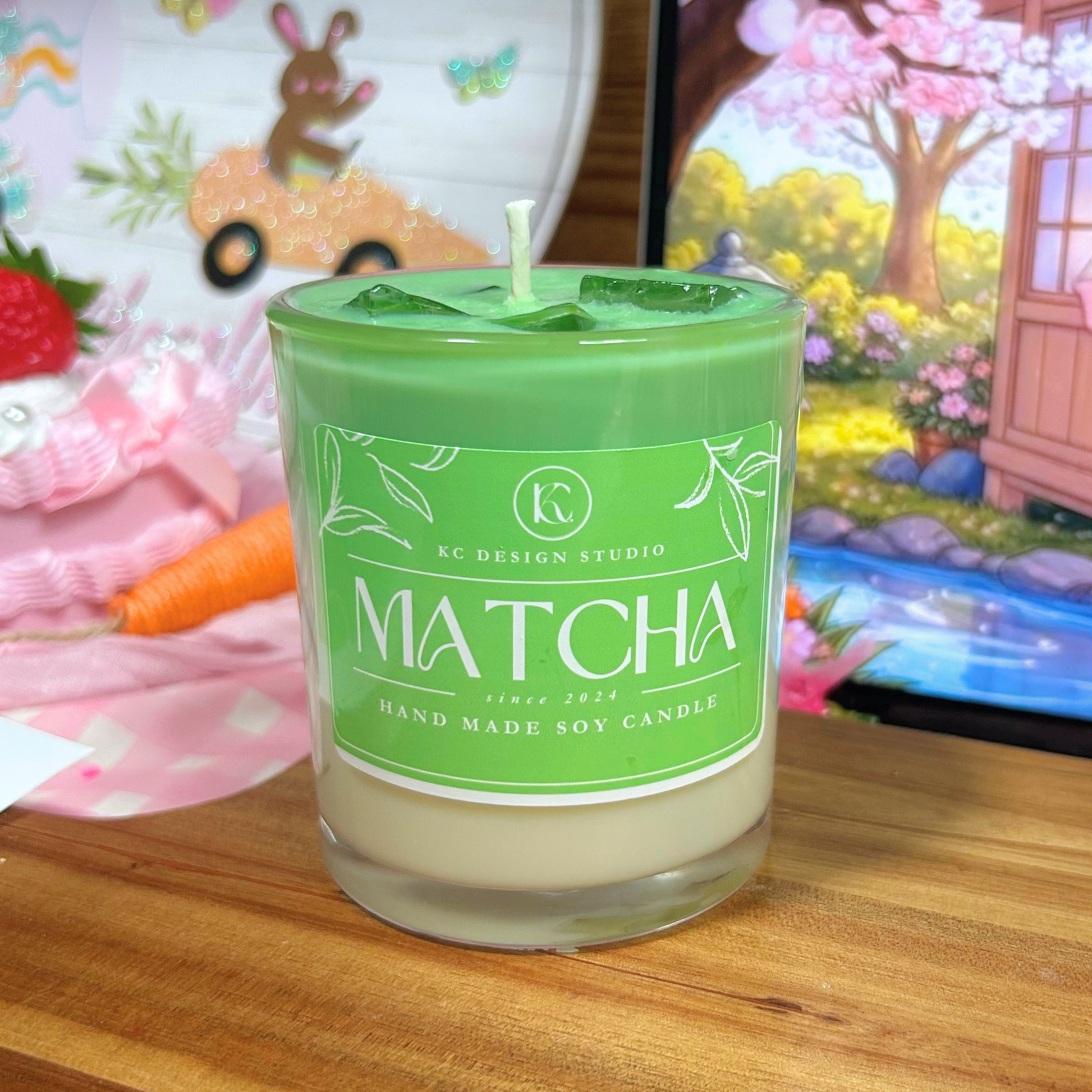 Matcha candle with a green label on a wooden surface, colorful background