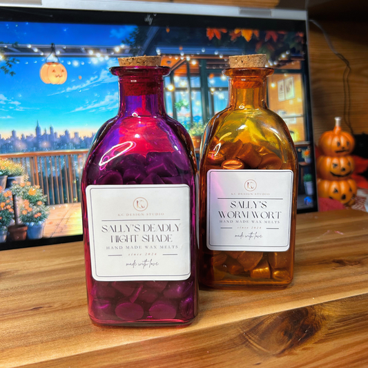 Two colorful wax melt bottles on a wooden surface with Halloween decorations in the background.