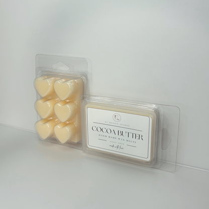 Cocoa Butter Cashmere wax melts placed against a background, showcasing label and heart-shaped packaging.