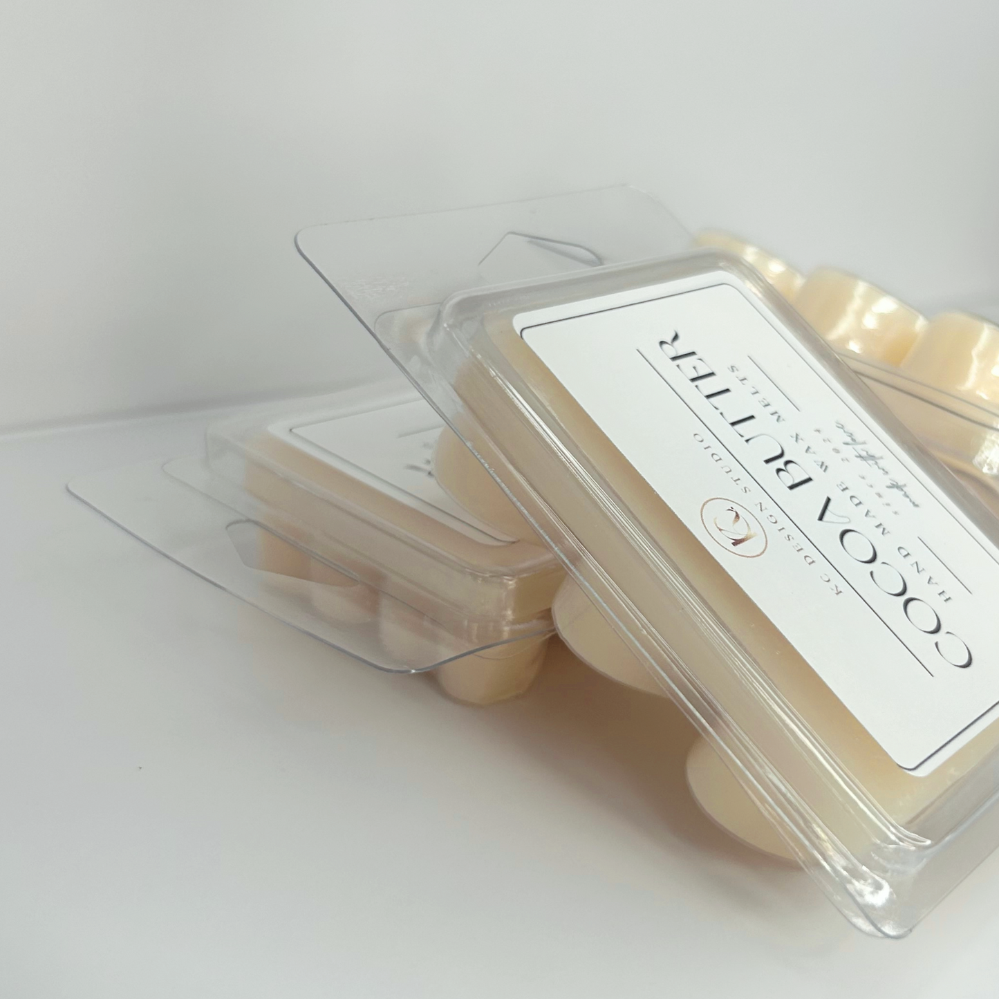 Angled Cocoa Butter Cashmere wax melts stacked with label and back side in heart-shaped packaging.