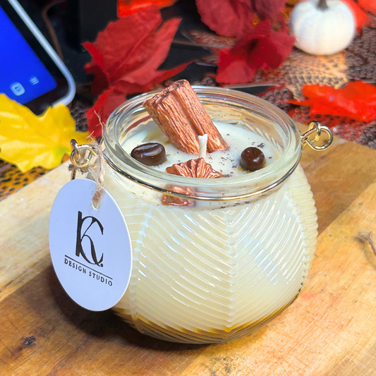 Angled view of Autumn Roast Candle – layered cappuccino espresso and marshmallow soy wax candle with cinnamon stick, brown flower, two coffee beans, and brown mica powder, cozy fall vibes.