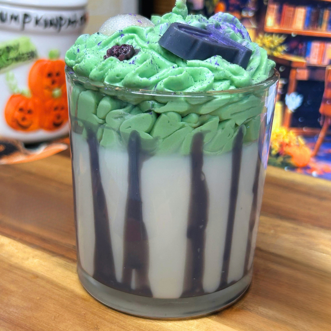 Back view of Beetlejuice-inspired 10 oz candle highlighting the black striped glass design and layered white and green wax.
