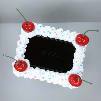 Top view of black Cake Vault Mini Locker with white frosting accent, sprinkles, and cherry details.
