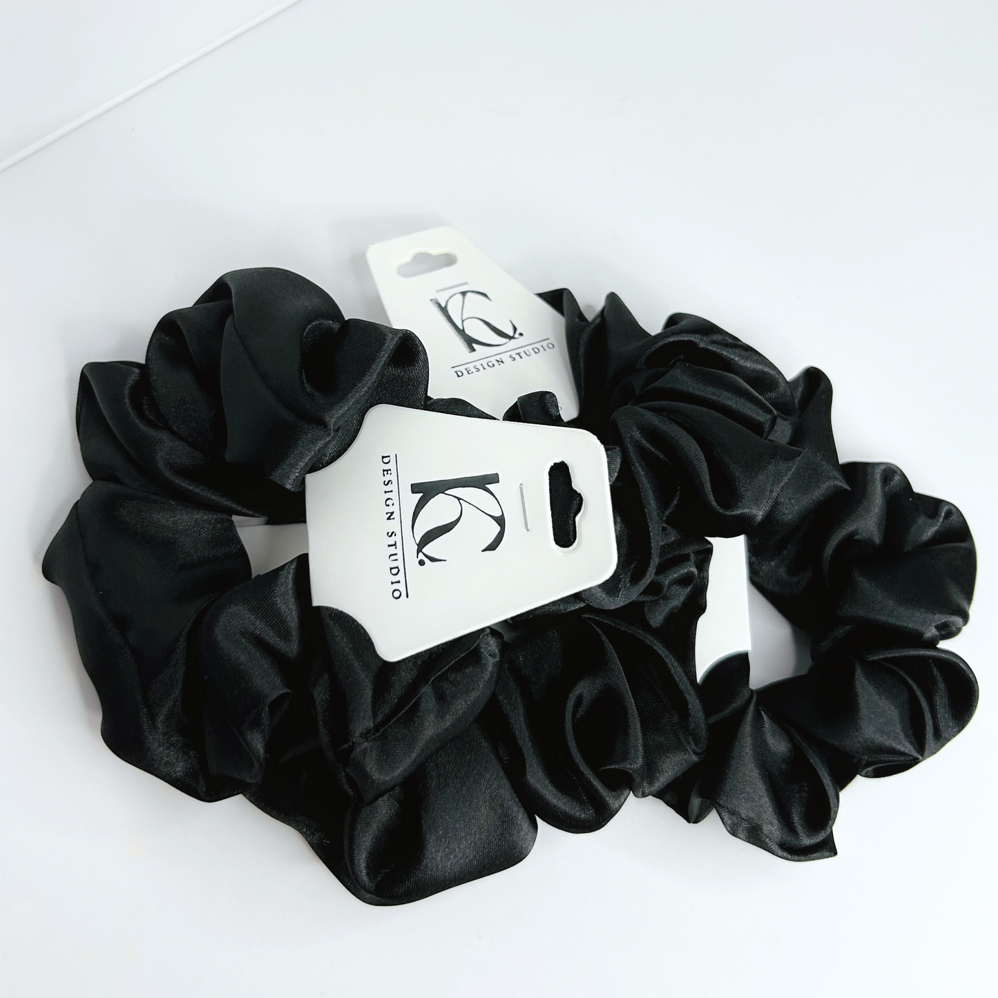 Elegant black silk scrunchie showcasing a luxurious texture.