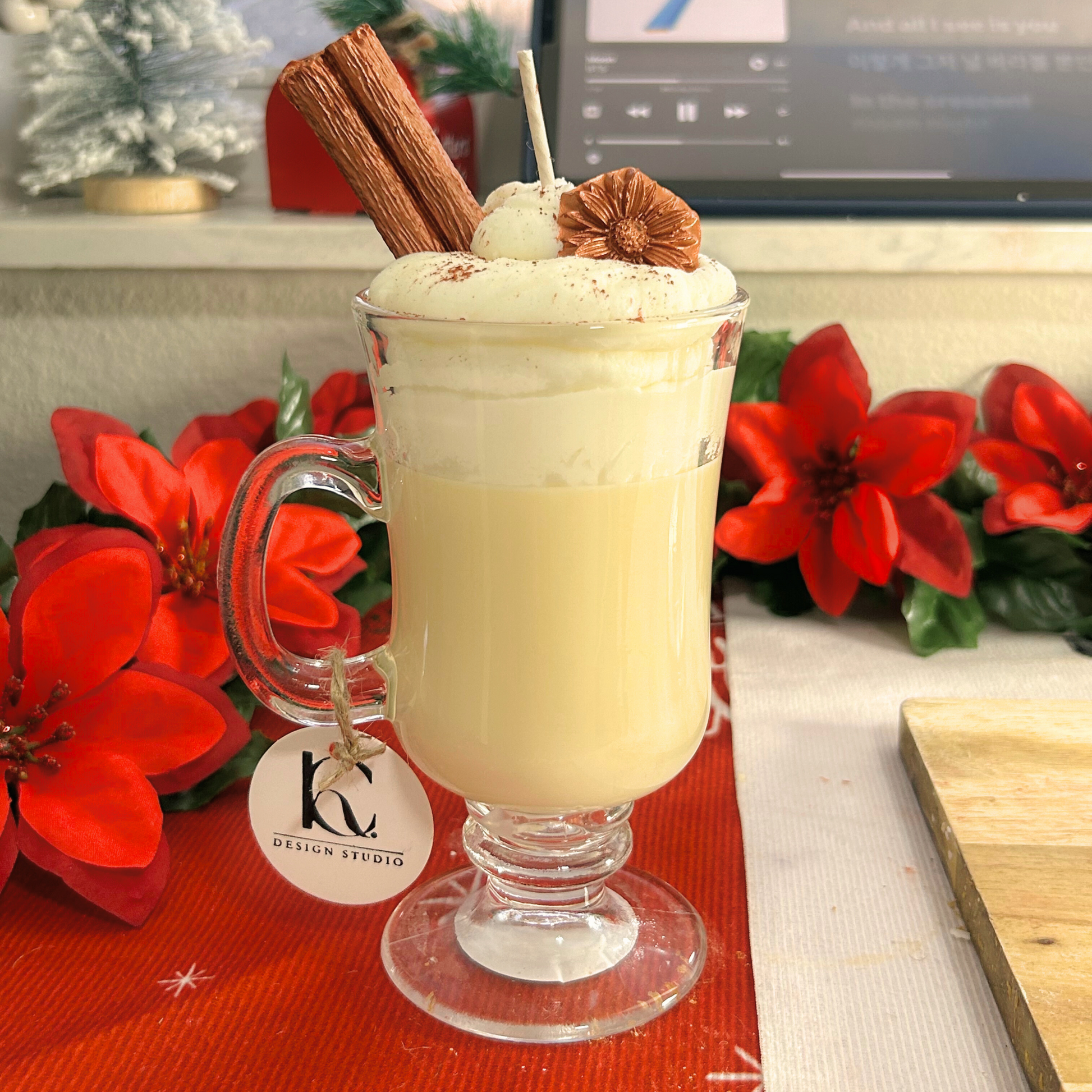 Front view of a Coquito Christmas candle from a distance, elegantly presented in an Irish cup with festive layers and toppings.