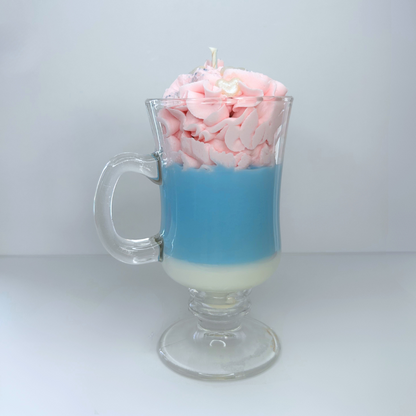 Front view of cotton candy-inspired candle in clear mug with pink whipped topping and heart sprinkles.