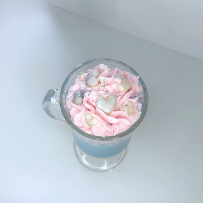 Top view of cotton candy candle showing pink whipped topping, heart sprinkles, and blue powder detail.
