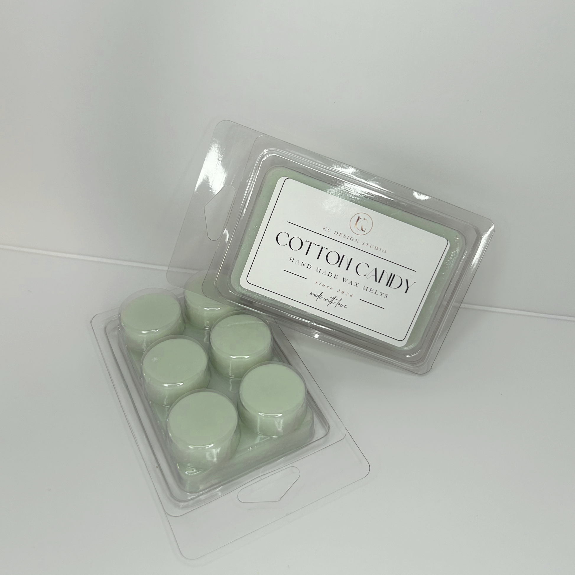 Cotton Candy wax melts against a background displaying the label and round-shaped back side.