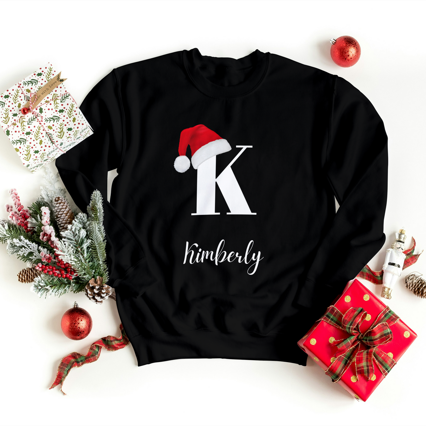 Custom Christmas sweatshirt in black with a Christmas hat on the initial and the option for a personalized name, perfect for the holiday season.