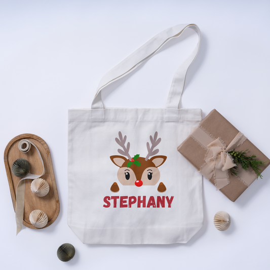 Custom Christmas white tote bag featuring a personalized initial with a reindeer design and customizable name for a festive, holiday accessory.