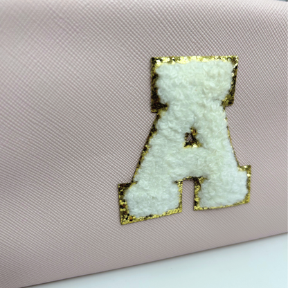 Close-up of light pink personalized initial cosmetic pouch embroidery details.