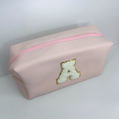 Light pink custom initial pouch – top view displaying zipper closure.