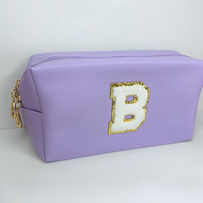Custom purple initial letter cosmetic pouch – front view with embroidered design.
