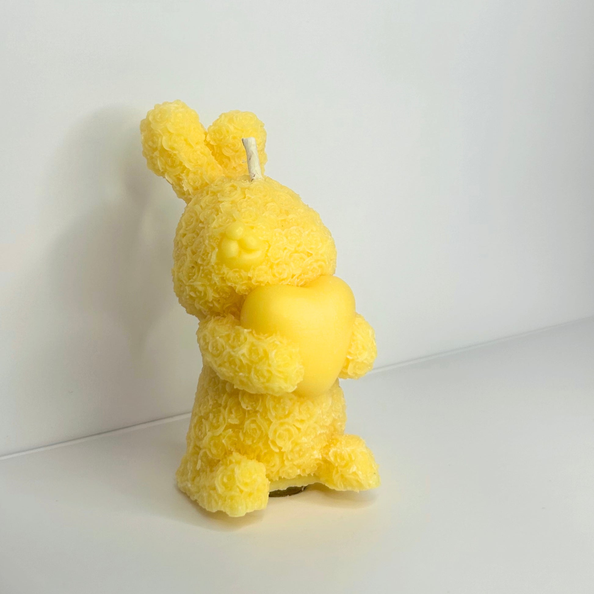 Front view of a Decorative Floral Bunny Candle, showcasing its whimsical design and vibrant yellow color.