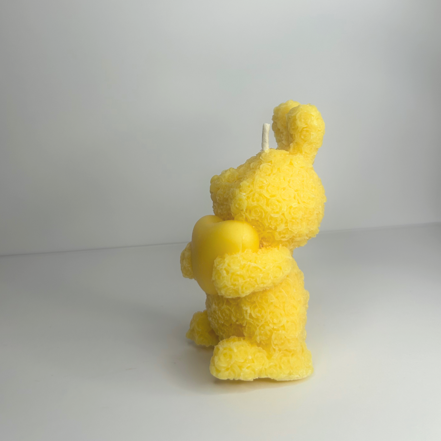 Side view of the Decorative Floral Bunny Candle, highlighting its charming yellow shape and floral details.