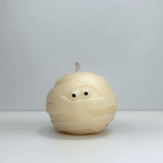 Front view of decorative mummy candle with visible eyes, perfect for Halloween decor.